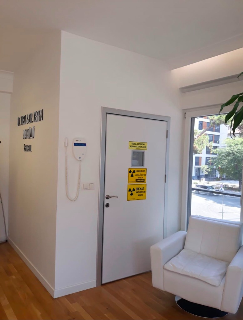 Radyasyon uyarı sembollü kurşun kaplı klinik kapısı